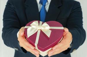 Businessman is giving heart box gift photo