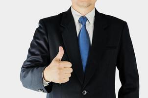 Businessman is doing thumps up sign over white background. Photo is focused at hand. Photo includes clipping path.