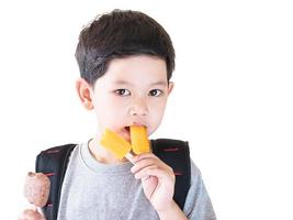 Boy eating ice cream isolated over white background photo