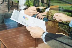 Two businessman discussing their chart in coffee shop photo