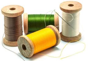 Isolated wooden spools of thread with a needle photo