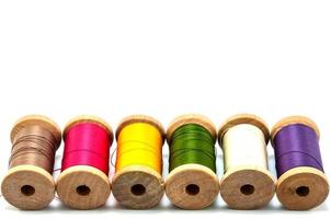 Isolated wooden spools of thread with a needle photo