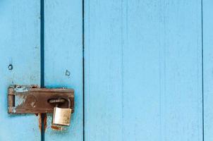 Old wooden door with rusty padlock and lock for background use photo