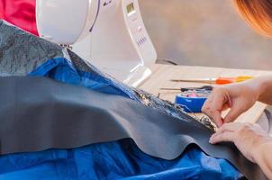 Tearing cloth with soft blurred of woman's hand, sewing machine and embroidery set photo