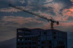 Tower crane in the high building construction site during twilight time photo