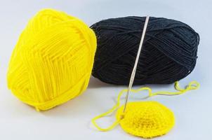 Yellow and black yarn balls with crochet hook photo