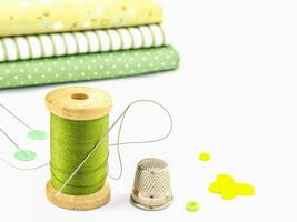 Wooden spool of thread embroidery set with cloth over white background photo
