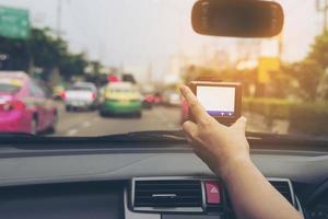 Man using navigator while driving a car in urban traffic road photo