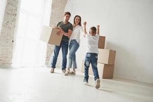 Dame un abrazo. estado de ánimo juguetón del niño. la familia tiene mudanza a una nueva casa. desempacar cajas de mudanza foto