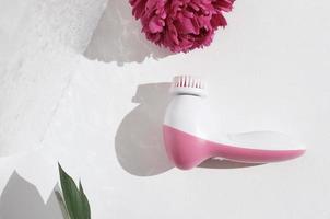 pink facial cleansing brush. Cosmetic tool for face care, scrubbing, exfoliating, removing blackhead, massaging. self and beauty care routine device photo