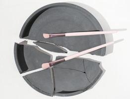 cosmetic eye shadow brushes on broken cement tray. minimal style. professional make up tools. white backround. photo