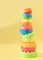 balancing round toy pyramid on yellow background. kids toys for fine motor skills development. toy market advertising, logic game for preschoolers photo