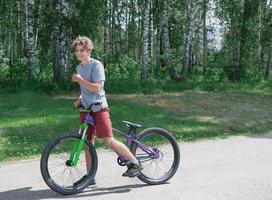 niño adolescente sonriente feliz en una bicicleta. foto