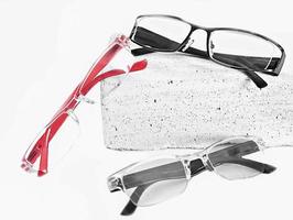 three various eyeglasses on trendy stone. Optical store, glasses selection, eye test, vision examination at optician, accessories concept. selective focus. photo