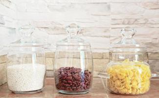 food storage and order in a kitchen. glass containers for grocery on a shelf. front view photo