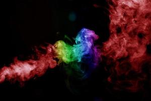 humo abstracto aislado sobre fondo negro, polvo de arco iris foto