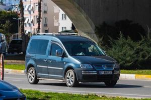 Antalya Turkey  March 04 2022 black Volkswagen Caddy   is  driving   on the street on a warm  autumn  day photo