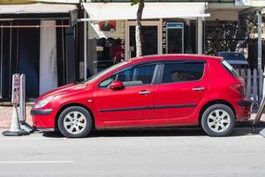 Antalya  Turkey March 04 2022   red Peugeot 307   is parked  on the street on a warm summer day against the backdrop of  building, park photo