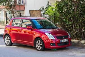 Antalya Turkey  March 04 2022 red Suzuki Swift  is parked  on the street on a warm   day photo