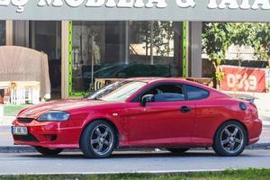 antalya turquía 04 de marzo de 2022 hyundai tiburon rojo está estacionado en la calle en un día cálido con el telón de fondo de un edificio, tienda foto