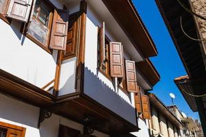 cierre la pared de una casa de piedra con ventanas y persianas de madera. antigua arquitectura europea foto