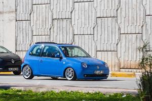 antalya turquía 04 de marzo de 2022 blue volkswagen lupo conduce rápido en la calle en un cálido día de verano con el telón de fondo de un puente foto