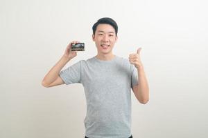 joven asiático con tarjeta de crédito foto
