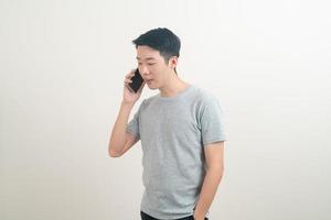 young Asian man using or talking smartphone and mobile phone photo