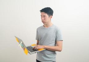 young Asian man holding laptop with stress face or working hard photo