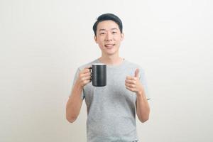 young Asian man holding coffee cup photo