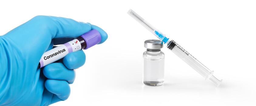 mano sosteniendo viola con muestra de sangre de coronavirus. jeringa médica y bollte con vacuna. foto