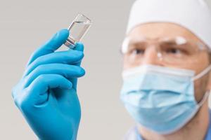 médico sosteniendo una viola con vacuna contra el virus de la corona. foto