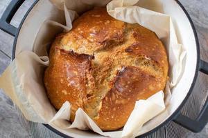 pan integral de masa fermentada con bonitos picos de corteza en horno holandés foto