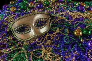 Pile of Mardi Gras beads with colorful carnival mask with copy space photo