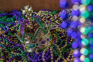 Pile of Mardi Gras beads with crown and bokeh photo