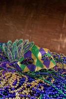 Pile of Mardi Gras beads with colorful carnival mask with copy space photo