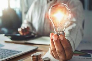 businessman hand holding light bulb. idea concept with innovation and inspiration photo