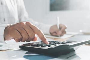 close up hand of businesswoman working on desk in office and using calculator and laptop with pen for calculate. cocept finance and accounting photo