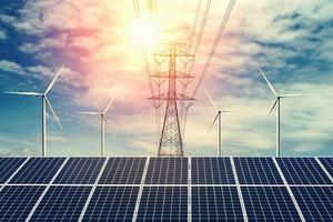 energía eléctrica en la naturaleza. concepto de energía limpia. panel solar con turbina y torre de alta tensión foto