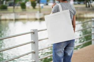 hipster woman holding white tote bag for mock up blank template photo