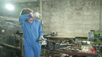 una joven ingeniera profesional de la industria trabaja con un uniforme de seguridad con herramientas de precisión de metalistería, tornos mecánicos y taller de piezas de repuesto en la fábrica de acero. video