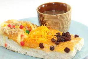 bakery is topped with raisins, shredded pork and foi thong, fresh daily in a blue plate. served with coffee on a white background photo