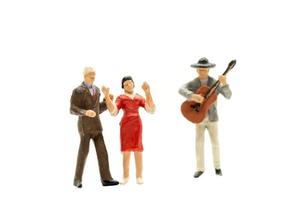 Miniature people Couple dancing with a guitarist playing the guitar photo