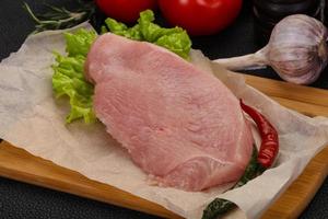 Raw Turkey steak served rosemary photo