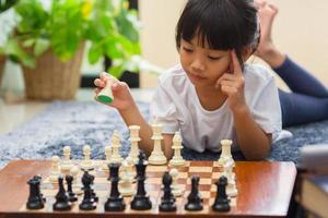 little girl having online chess lesson, e-education, distance learning photo