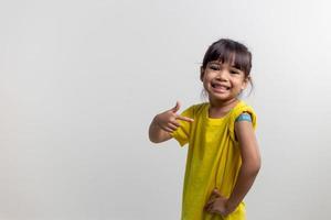 COVID 19 Vaccines for Kids concept. Studio a portrait of an adorable Asian girl after getting his first dose of vaccine. Immune, Safe, Available, Back to school. photo