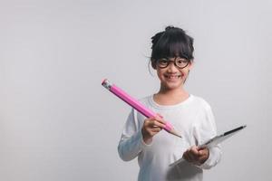 Excited young girl kid holding up big pencils in her hands.Back to school. photo