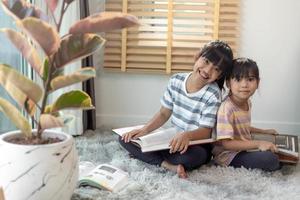 Concentrated siblings reading a book photo