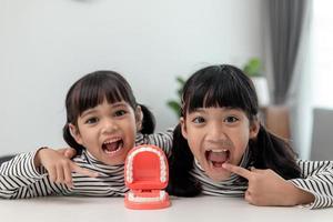 Cute Asian child playing with doctor dentist toy set, child shows how to clean and care for teeth. Dentistry and medicine, photo