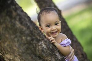 niña mirando desde detrás de un abedul foto